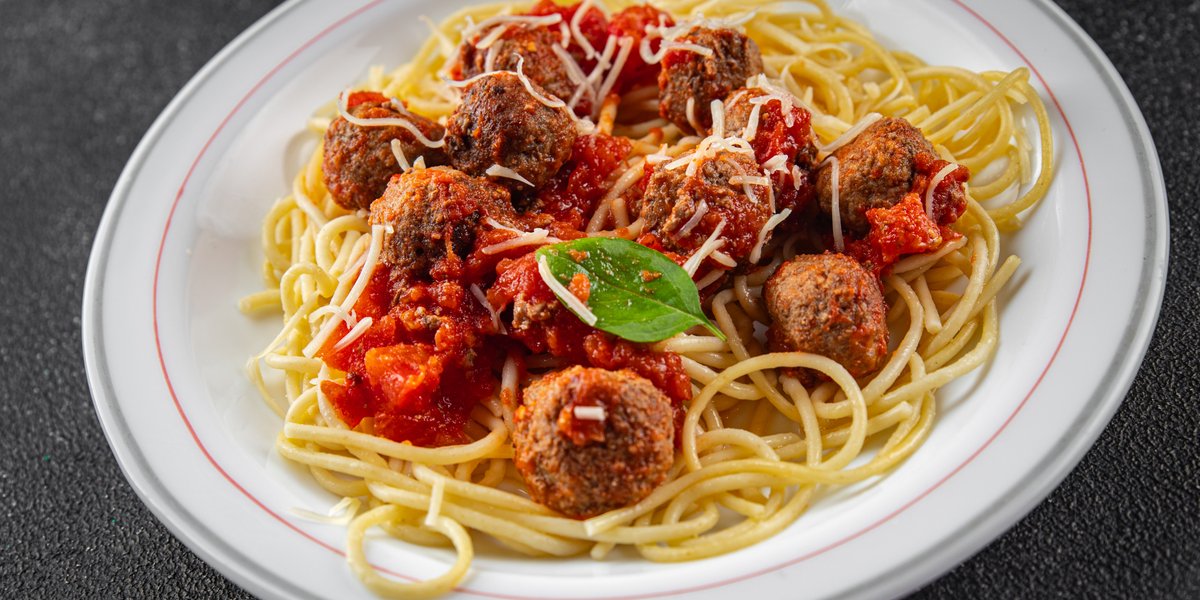 Spaghetti and meatballs with tomato sauce, parmesan, and basil